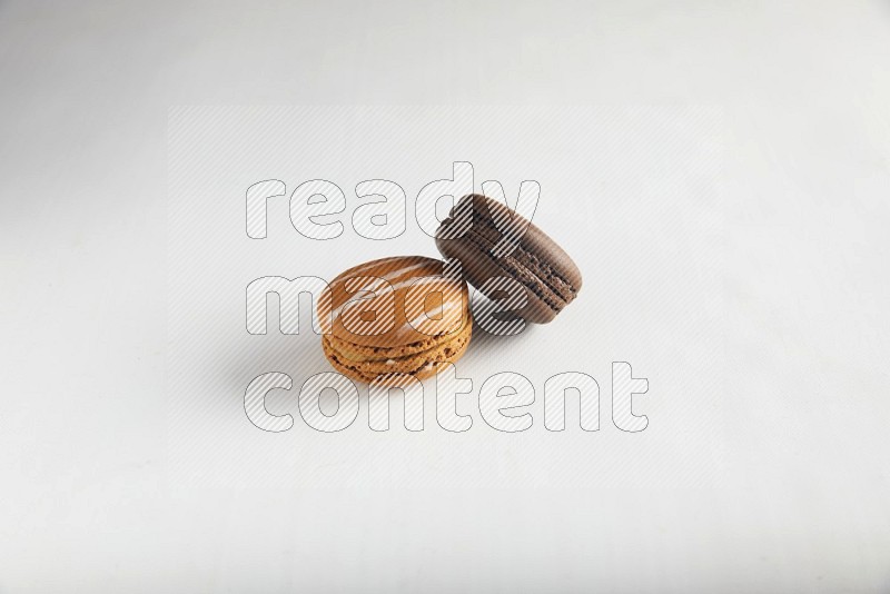 45º Shot of of two assorted Brown Irish Cream, and Brown Dark Chocolate macarons on white background