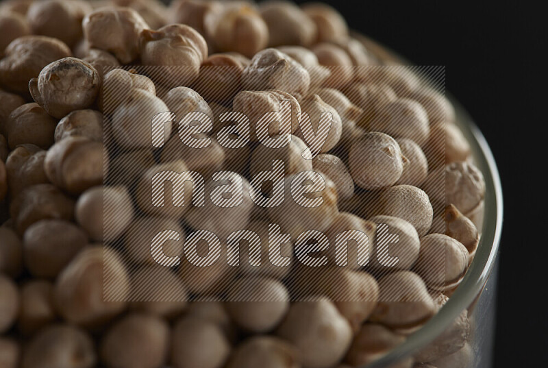 Chickpeas in a glass jar on black background