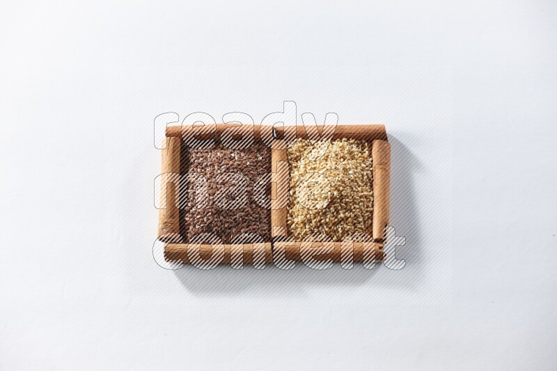 2 squares of cinnamon sticks full of flaxseeds and sesame on white flooring