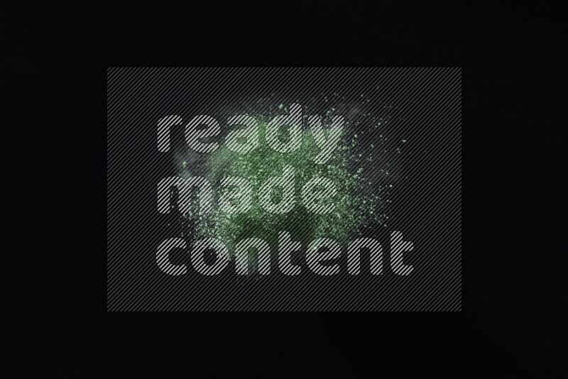 Green powder explosion on black background