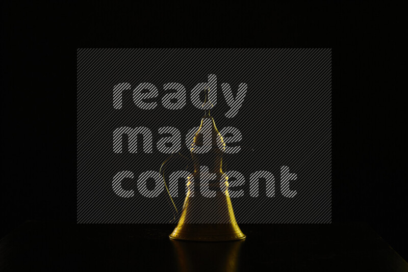 A turkish coffee pot with colored rim light against black background