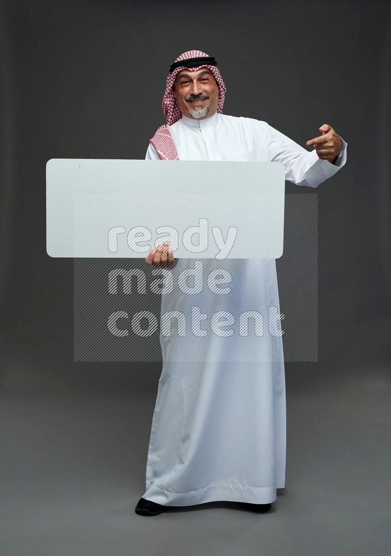 Saudi man with shomag Standing holding social media sing on gray background