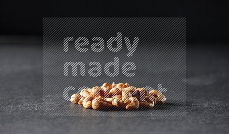 A bunch of cashews on a black background in different angles