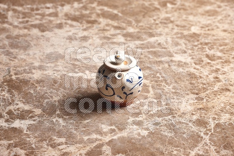 Pottery tea pot on Beige Marble Flooring, 45 degrees
