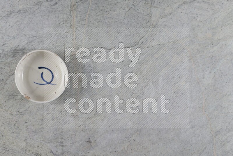 A white pottery bowl on grey marble background