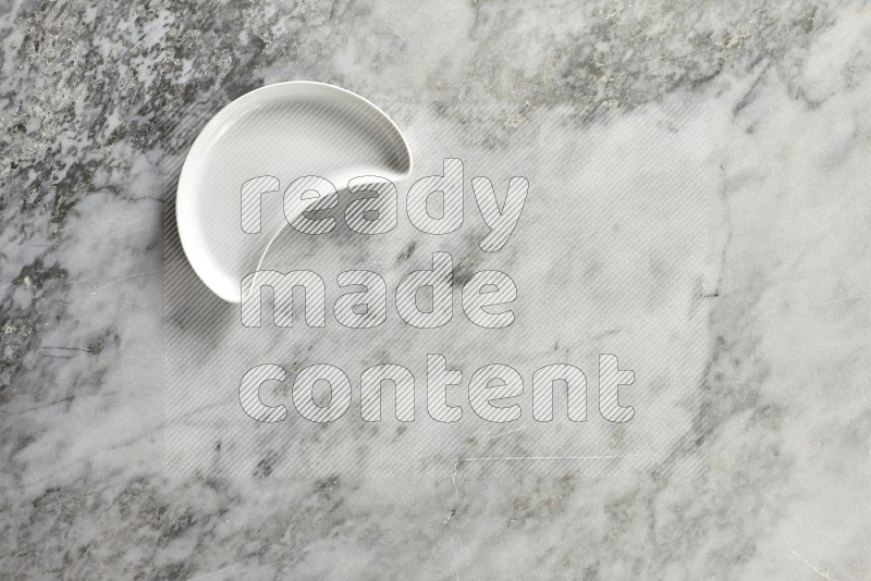 A pottery crescent plate on grey marble background