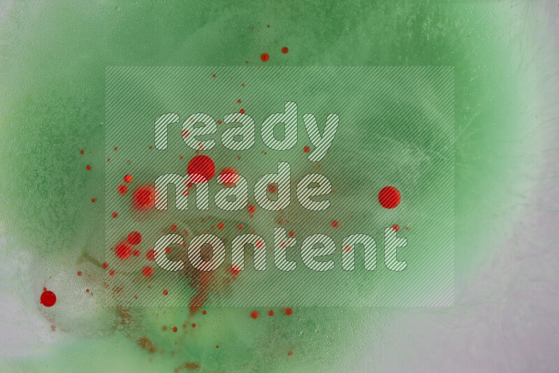 تلتقط الصورة تناثرا للطلاء الأحمر علي خلفية خضراء