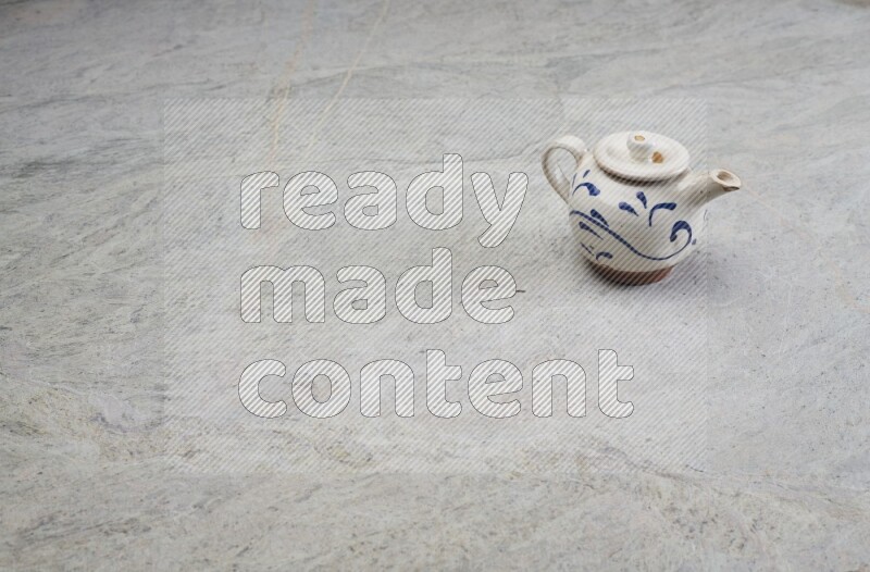 A pottery teapot on grey marble background