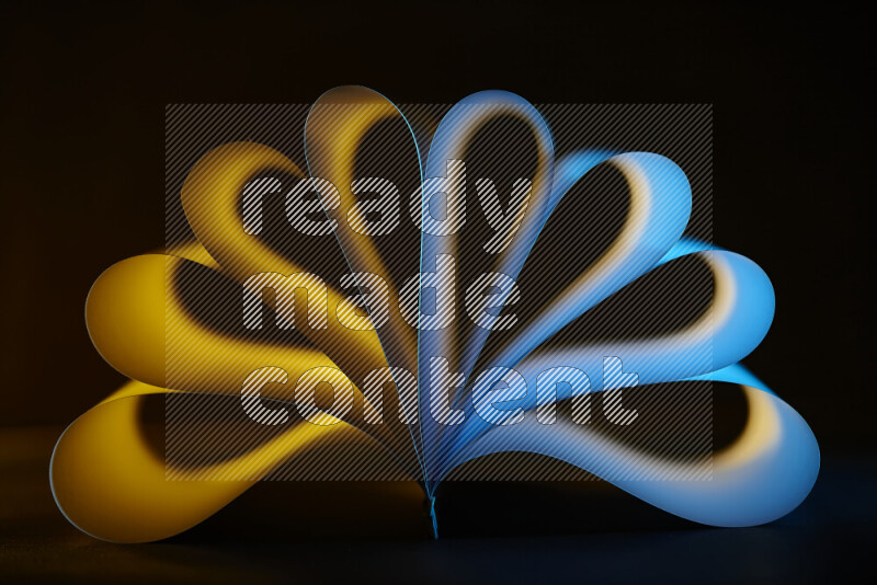An abstract art piece displaying smooth curves in yellow and blue gradients created by colored light