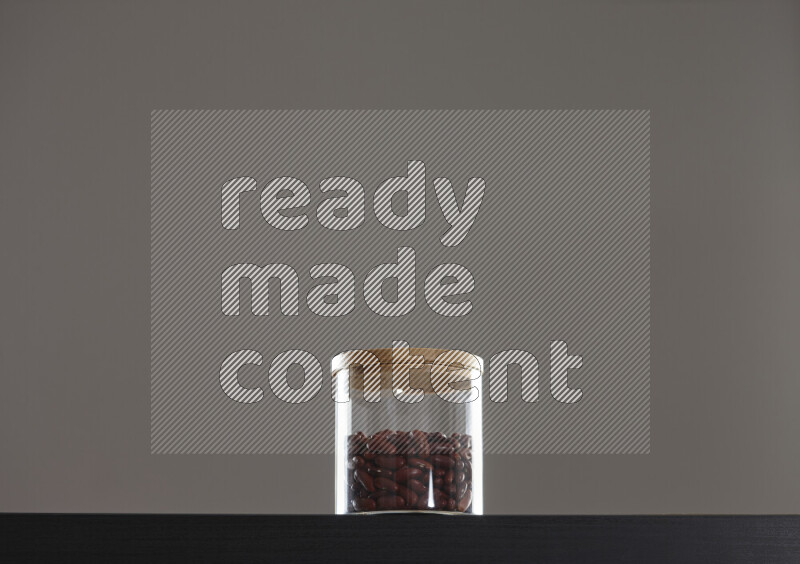 Red kidney beans in a glass jar on black background
