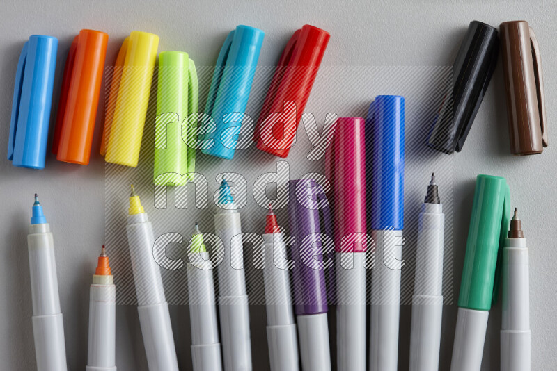 An arrangement of coloring pens in different colors on grey background