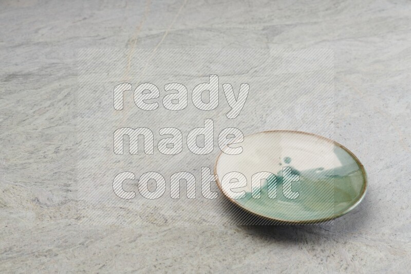 A multicolored pottery plate on grey marble background