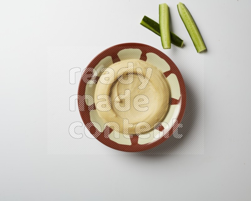 Plain hummus in a traditional plate on a white background
