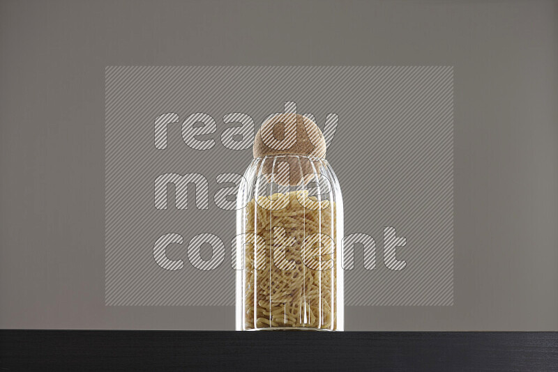 Snacks in a glass jar on black background
