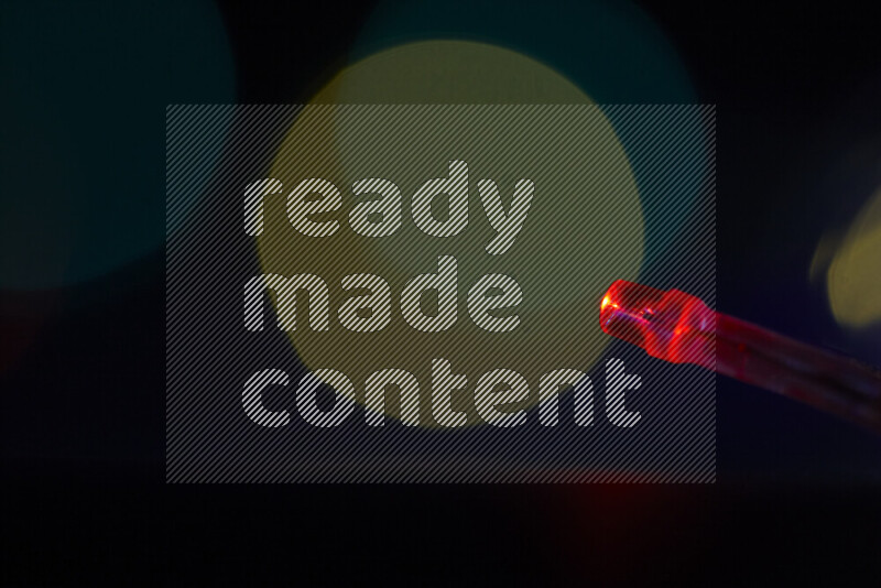 Light bulbs glowing against backdrop of multicolord bokeh