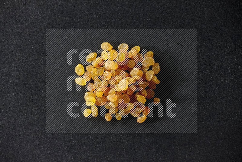 Yellow raisins isolated on a black background in different angles