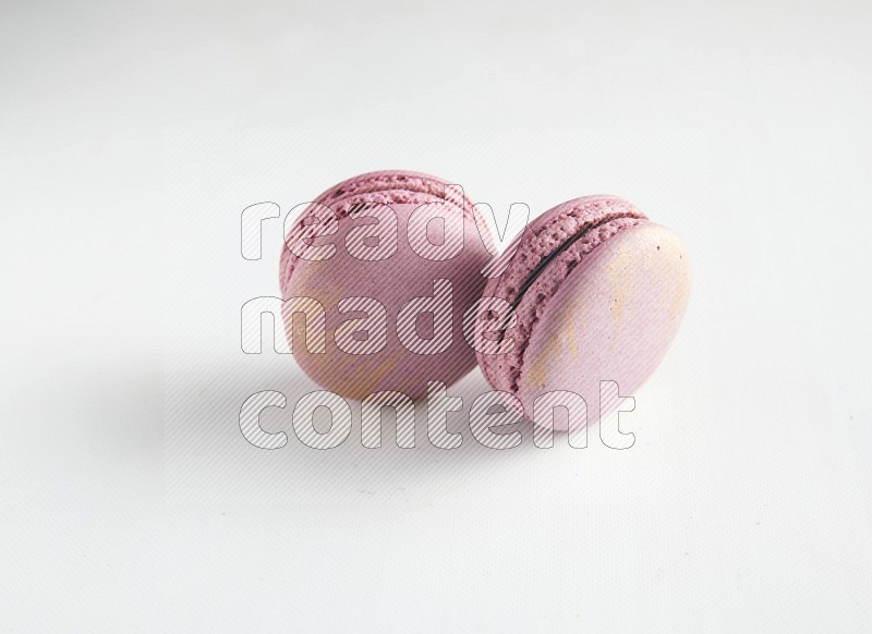 45º Shot of two Purple Strawberry macarons on white background