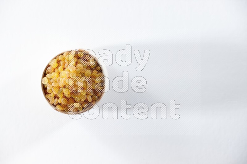 A beige ceramic bowl full of raisins on a white background in different angles