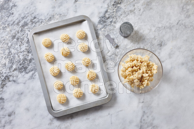 Kahk step by step with its ingredients ghee, sugar, flour, sesame, yeast, water and kahk flavor on grey marble background