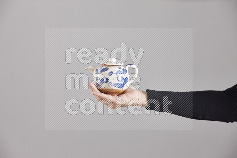 A woman in black abaya holding different pottery essentials in different positions