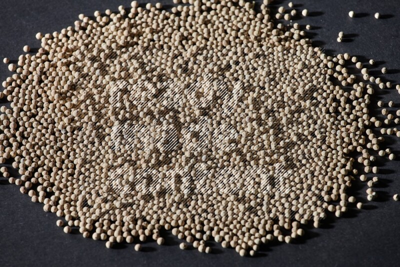 White pepper beads on black flooring