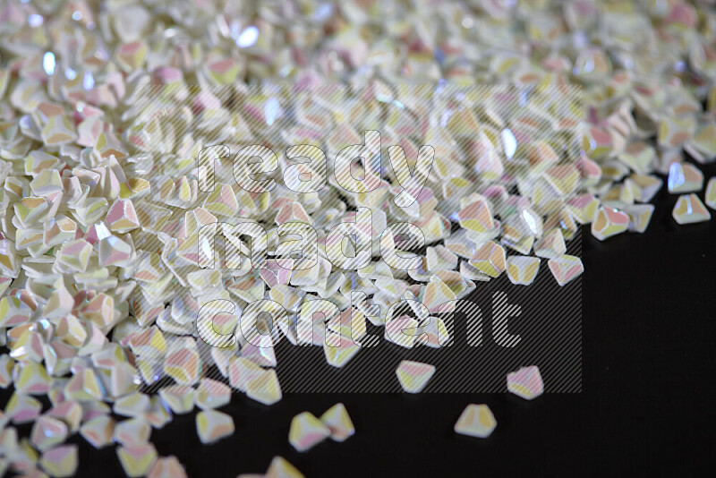 Colorful plastic shards for decoration scattered on a black background