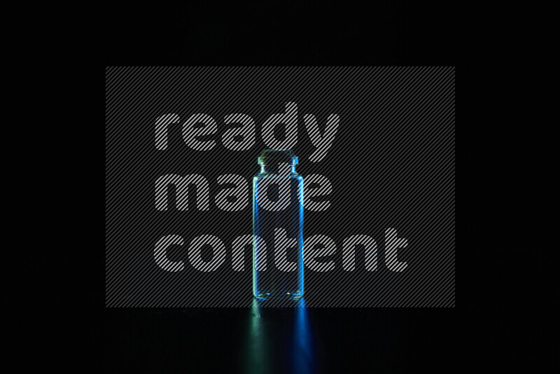 Glassware with rim light in blue and green against black background