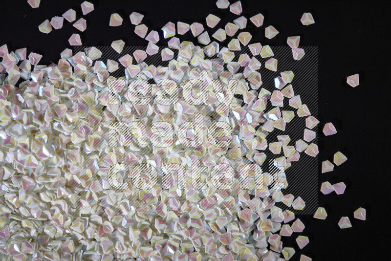 قطع صغيرة بلاستيكية ملونة للزينة متناثرة على خلفية سوداء