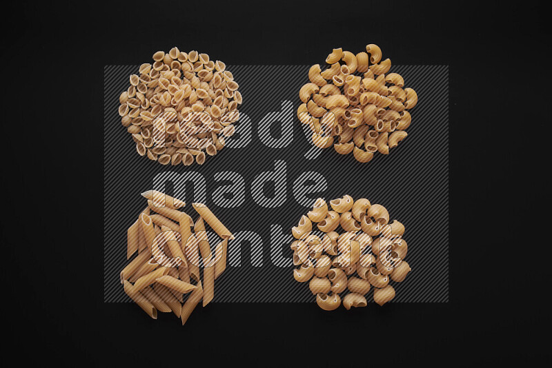 Different pasta types in bunches on black background