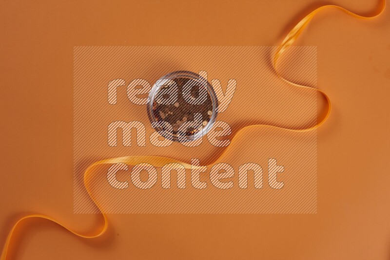 An orange collection of sewing and tailoring tools arranged on a orange background