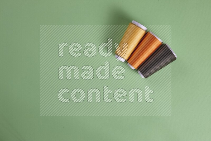 A collection of sewing and tailoring tools arranged on a green background