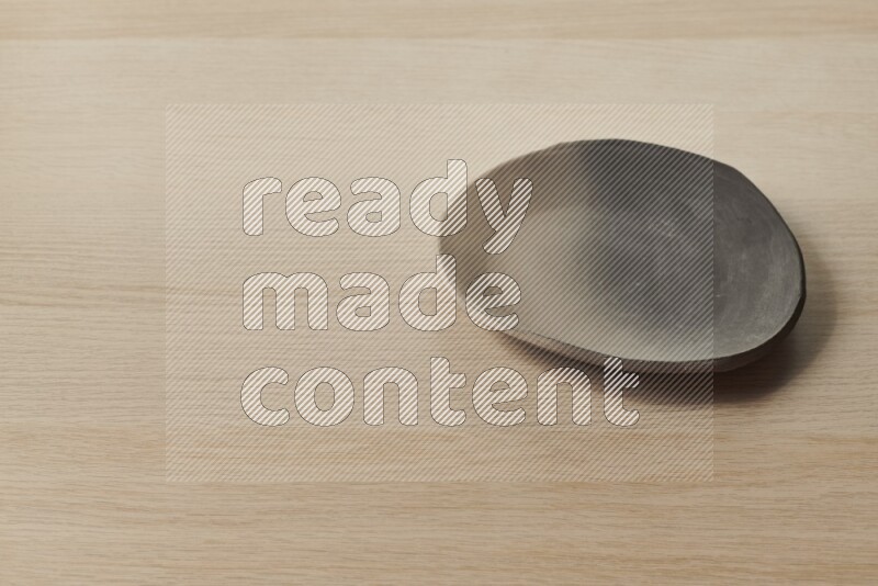 A multicolored pottery plate on light wooden background