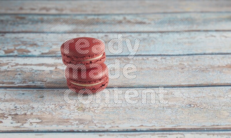 45º Shot of two Red Velvet macarons on light blue wooden background