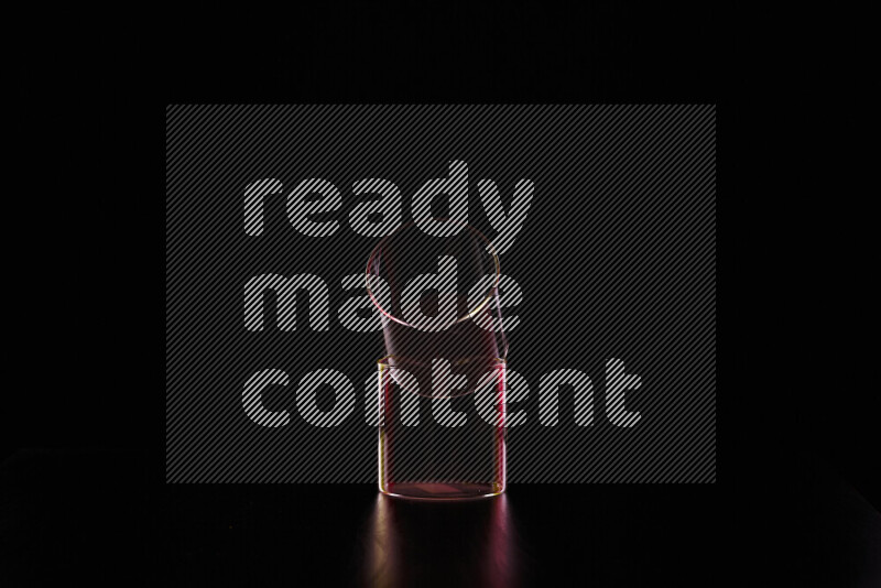 Glassware with rim light in red and yellow against black background