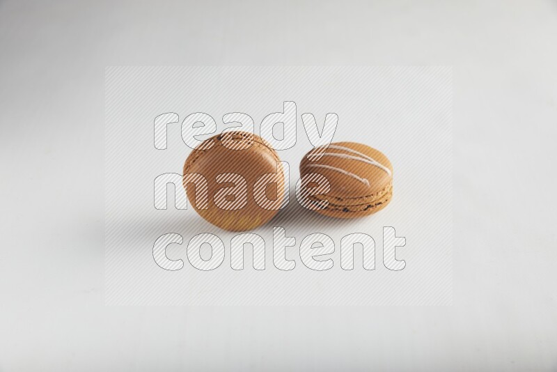 45º Shot of of two assorted Brown Irish Cream, and Brown Coffee macarons  on white background