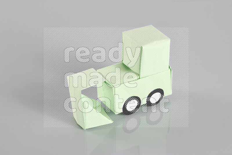 Origami bulldozer on grey background