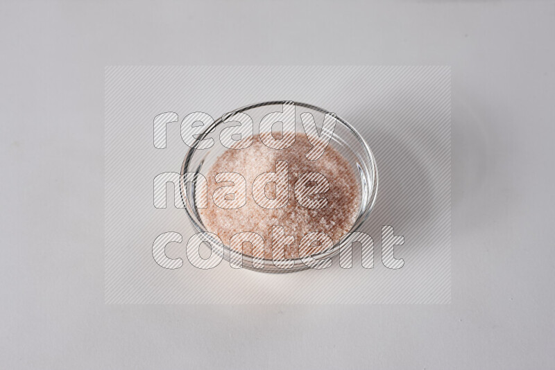 A glass bowl full of fine himalayan salt on white background