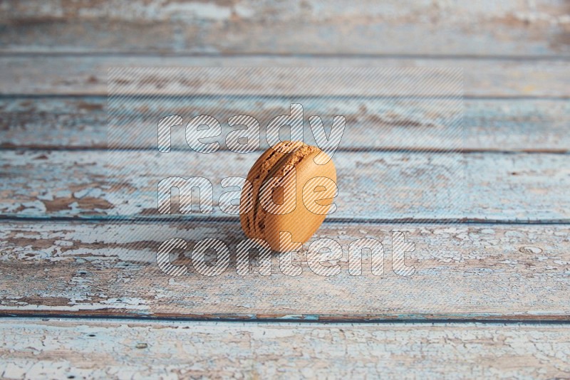 45º Shot of Brown Maple Taffy macaron on light blue wooden background