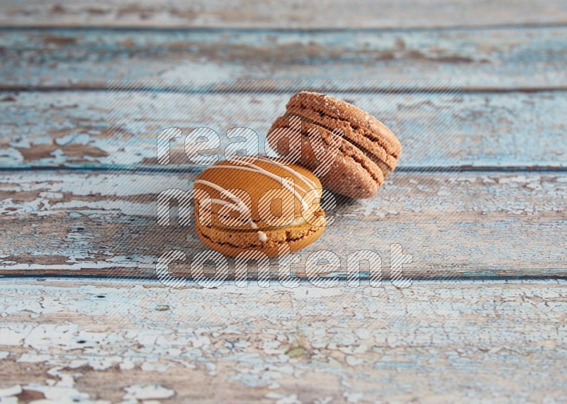 45º Shot of of two assorted Brown Irish Cream, and Brown Hazelnuts macarons  on light blue background