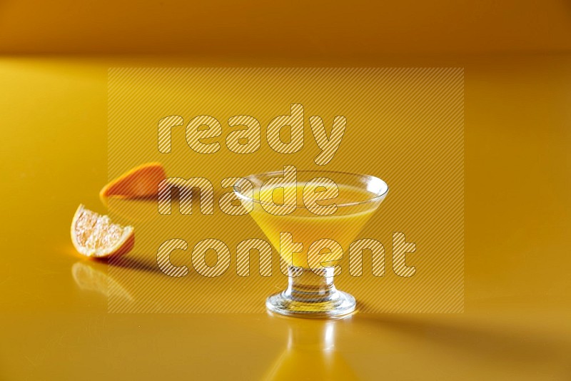 glass of orange juice on yellow background