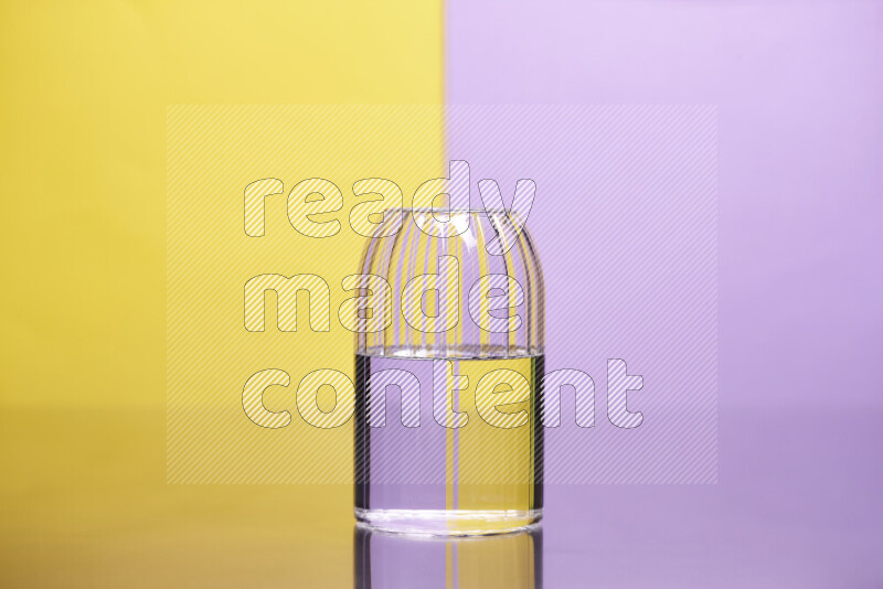 تظهر الصورة أواني زجاجية ممتلئة بالماء موضوعة على خلفية من اللونين الأصفر والأرجواني الفاتح