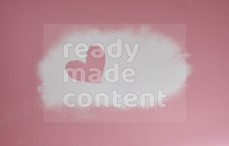 A heart drawn with powder on pink background