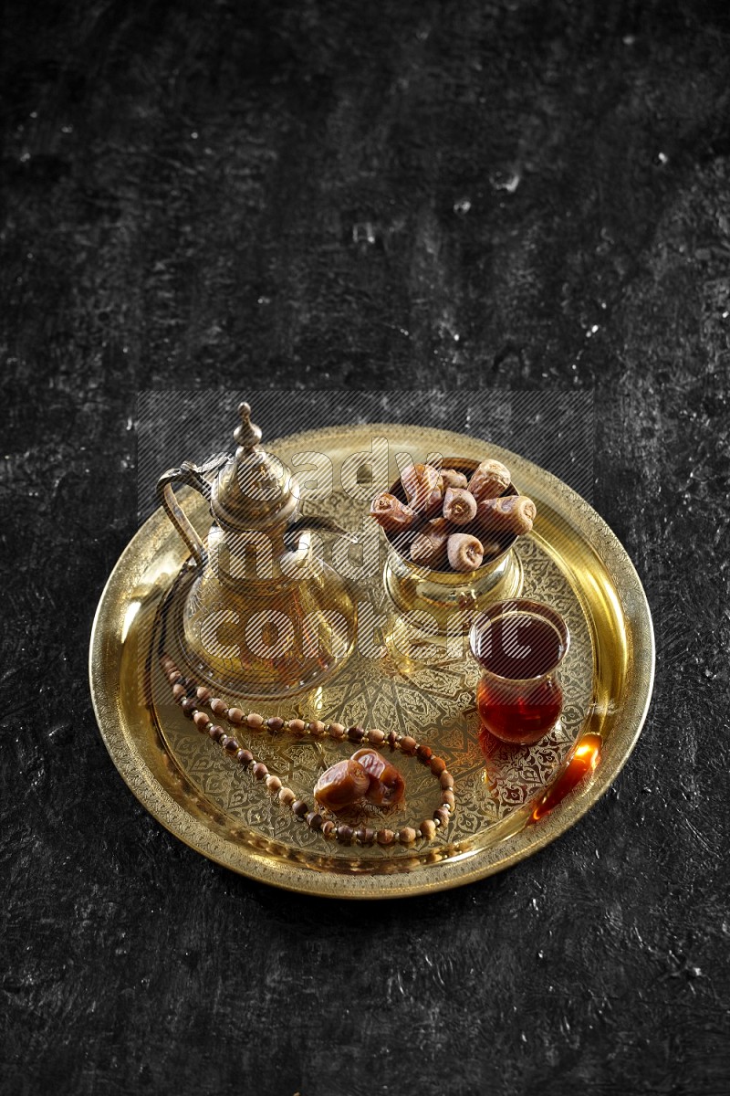 Dates with a drink on a metal tray in a dark setup