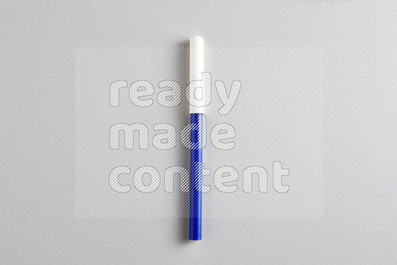 لقطة مقربة تظهر قلما ملونا واحدا بغطاء على خلفية رمادية