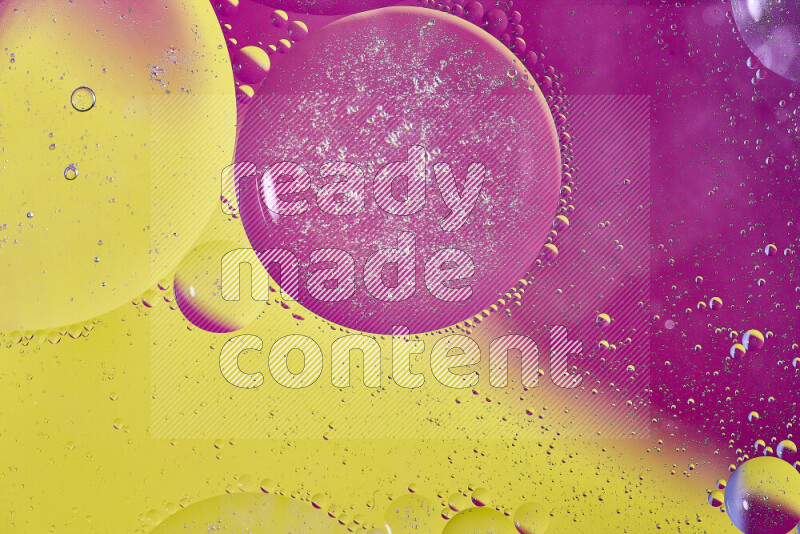 لقطات مقربة لفقاعات من الزيت على سطح الماء باللون الأصفر والوردي