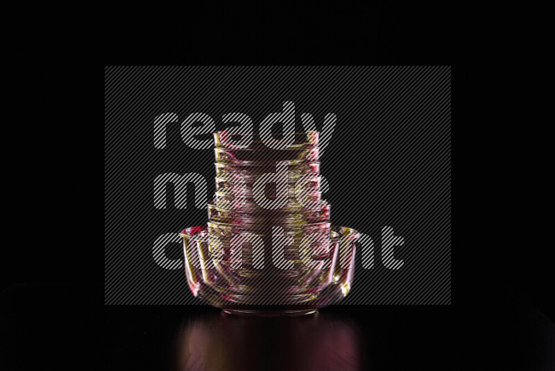 Glassware with rim light in red and yellow against black background