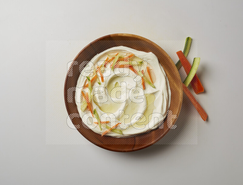 Lebnah garnished with sliced carrots & cucumber in a wooden plate on a white background