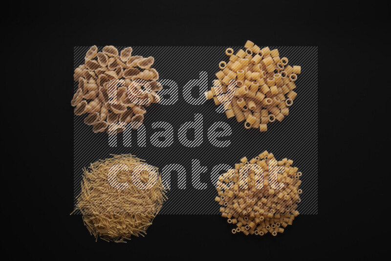 Different pasta types in bunches on black background