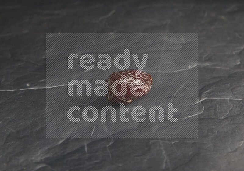 one madjoul date on a black textured background