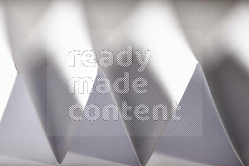 صورة مجردة مقربة تظهر طيات ورقية هندسية حادة بتدرجات اللون الرمادي